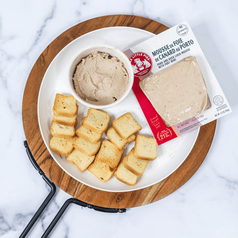 A beautifully arranged plate of toast alongside a vibrant Mousse de Foie de Canard au Porto, inviting you to enjoy a tasty snack.