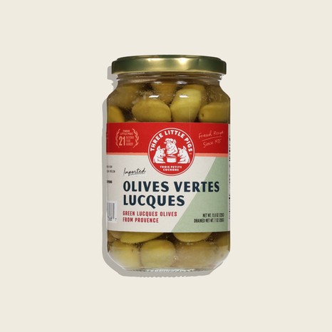 Jar of olives with a Three Little Pigs label on a beige background