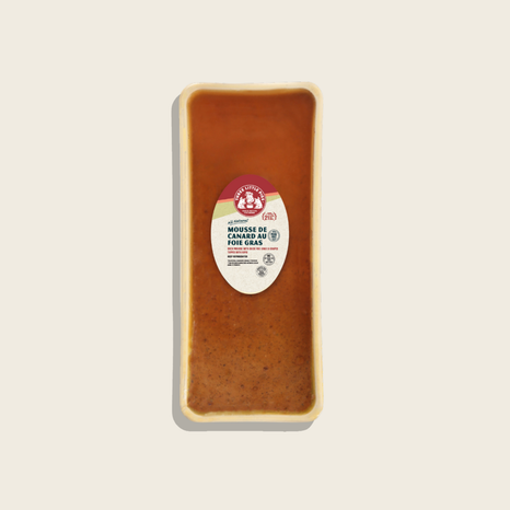 Rectangular block of duck liver mousse with a label on a beige background