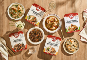 Assorted food packages and dishes on a wooden table with visible branding.